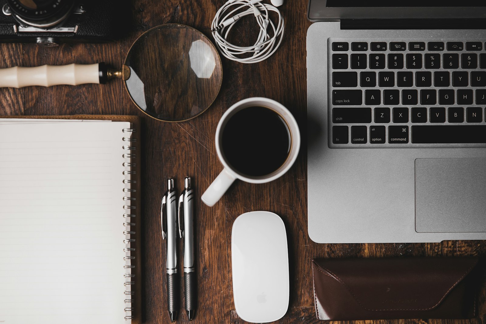 Notebook checklist next to a laptop and coffee on a home desk