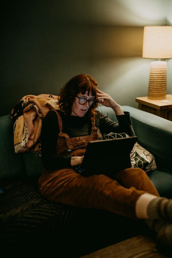 Solo freelancer at a home desk looking frustrated at a laptop