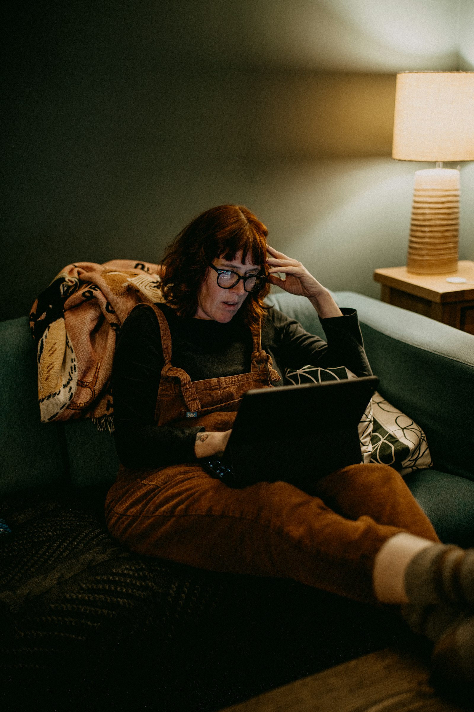 Solo freelancer at a home desk looking frustrated at a laptop