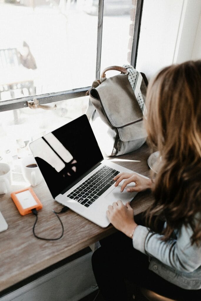 Freelance graphic designer reviewing a project quote on a laptop at a home desk