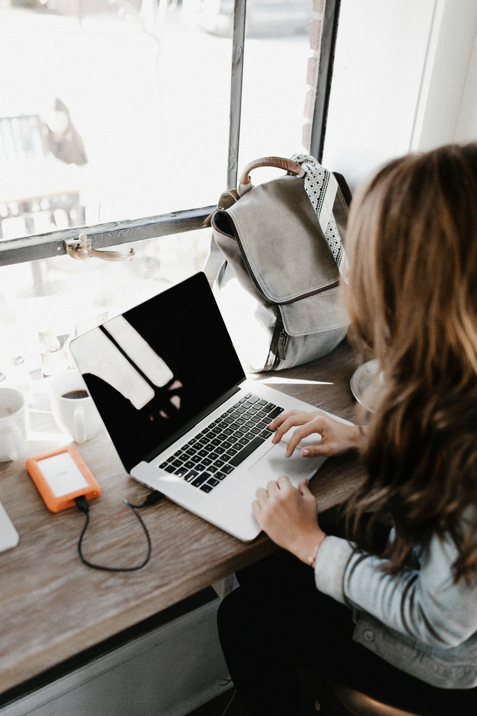 Freelance graphic designer reviewing a project quote on a laptop at a home desk