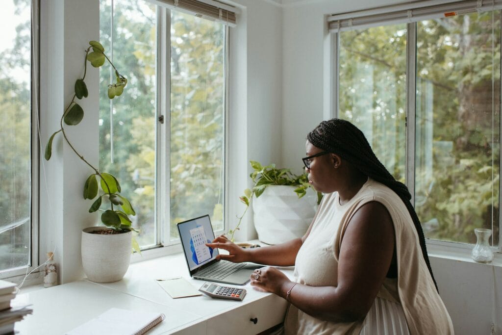 Freelancer at a home desk comparing business bank account options on a laptop