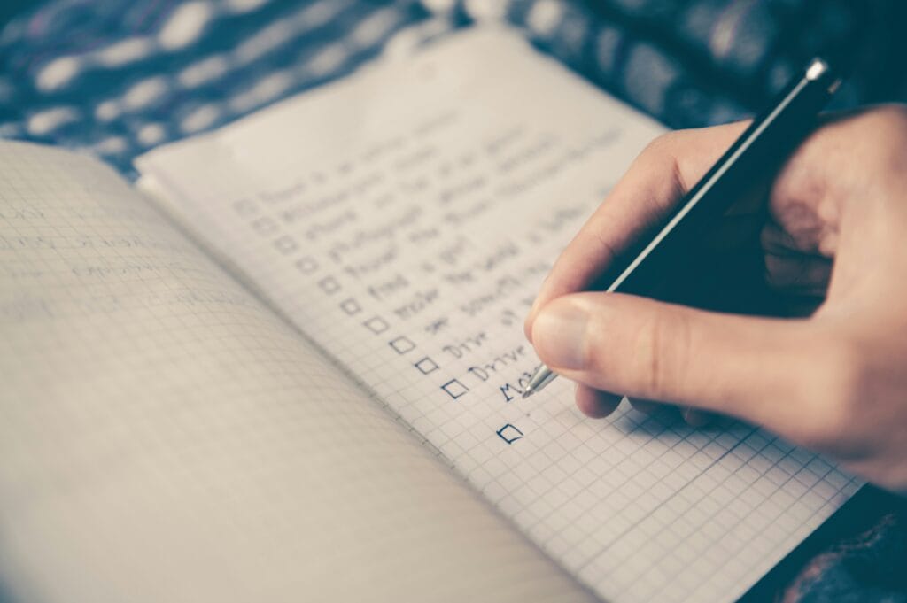 Printed freelancer tax setup checklist next to a notebook and laptop